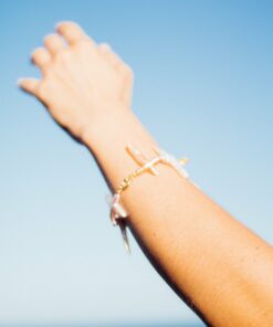 Joya artesanal con perlas naturaesl cruzadas y cierre dorado, diseño femenino inspirado en el mar.